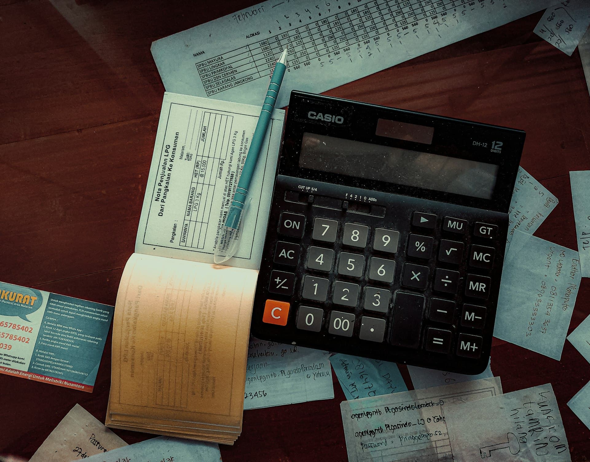 Calculadora, caneta e talão de notas fiscais sobre a mesa