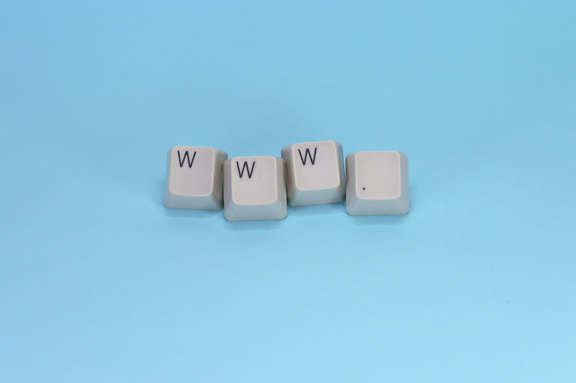 Teclas de teclado soltas formando www. sobre fundo azul