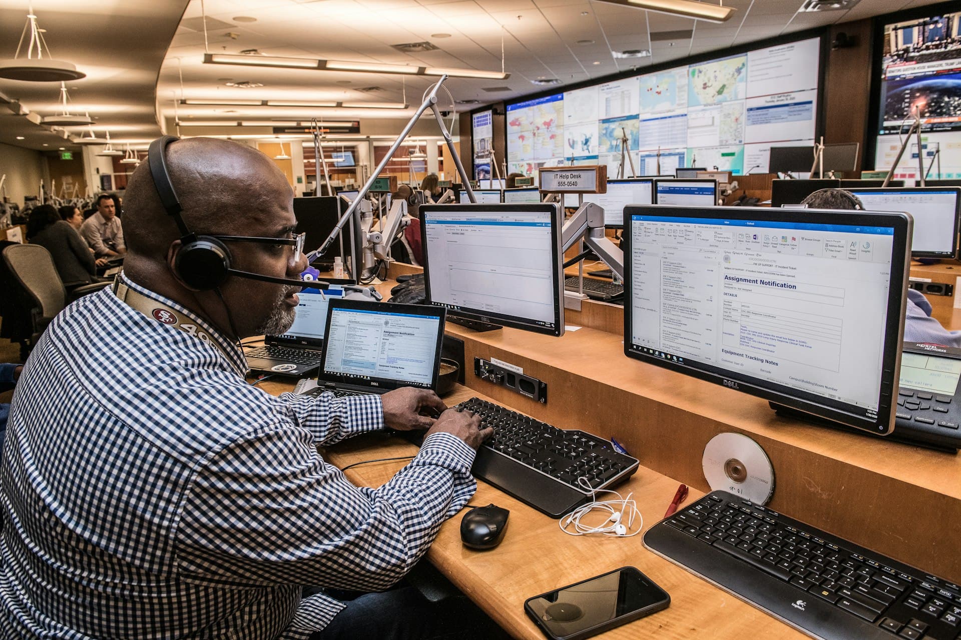 Profissional numa central de operações com vários monitores